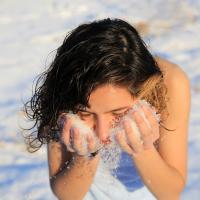 Kvinde putter sne i ansigtet
